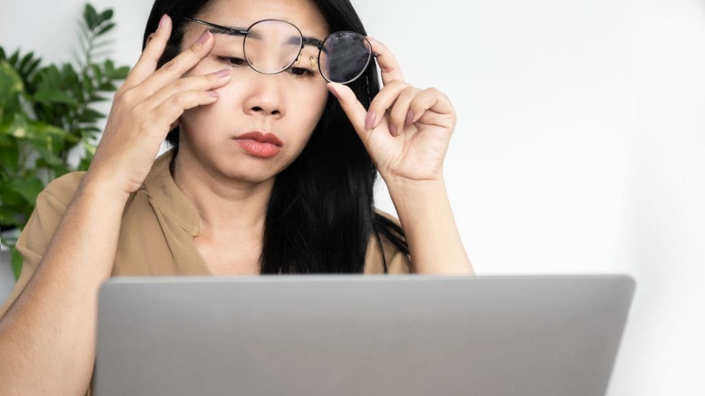 Người đeo kính nhìn màn hình mệt mỏi